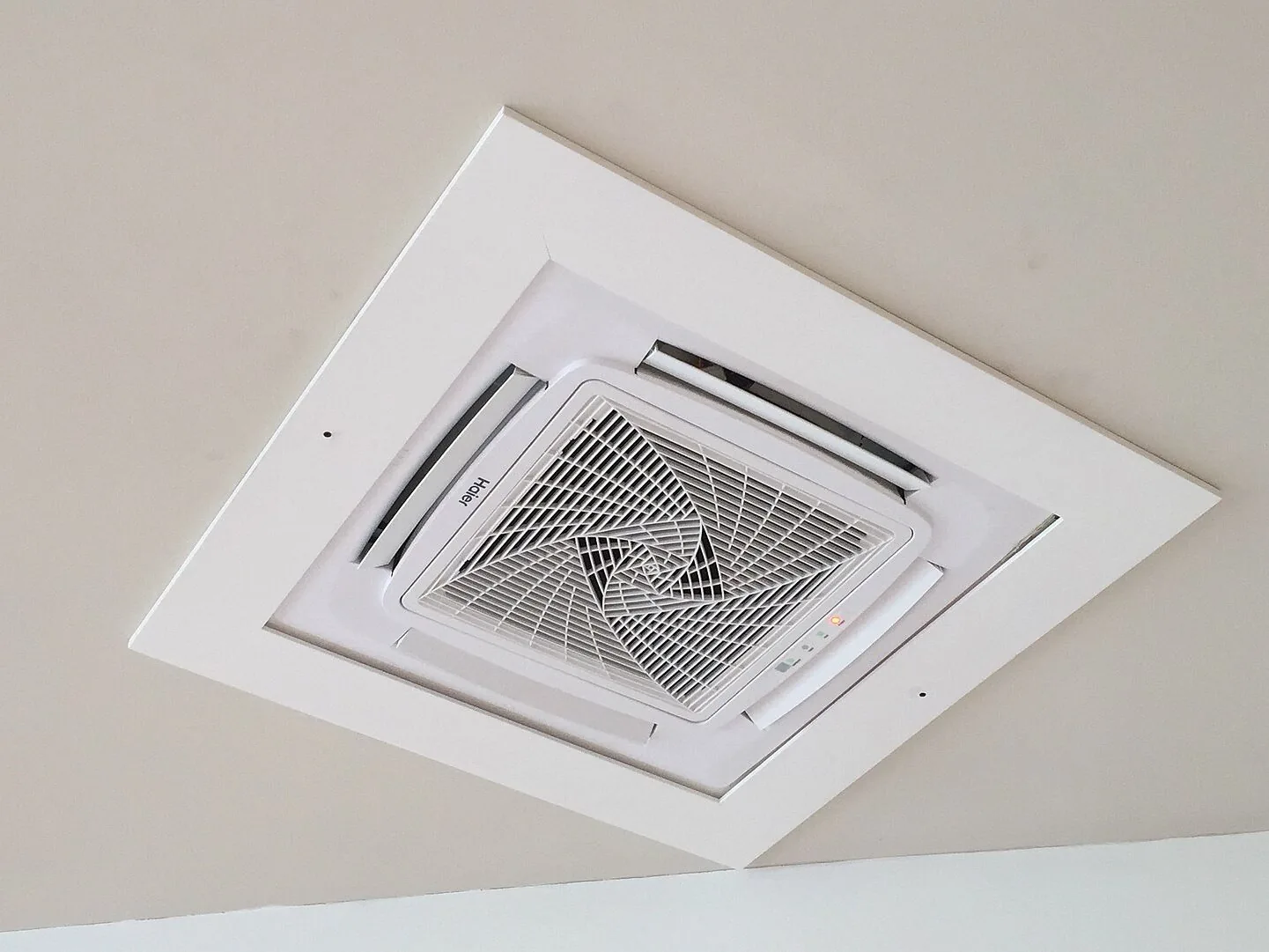 A ceiling cassette air conditioner set into a white ceiling