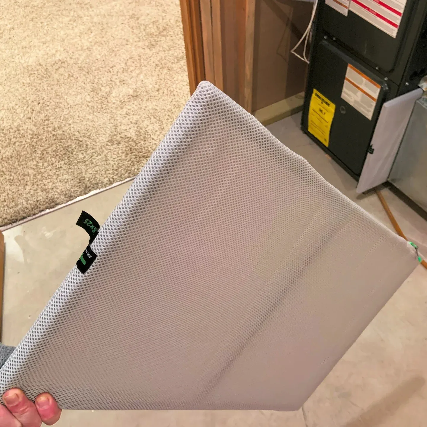 A pleated air filter being slid out of an air handling unit