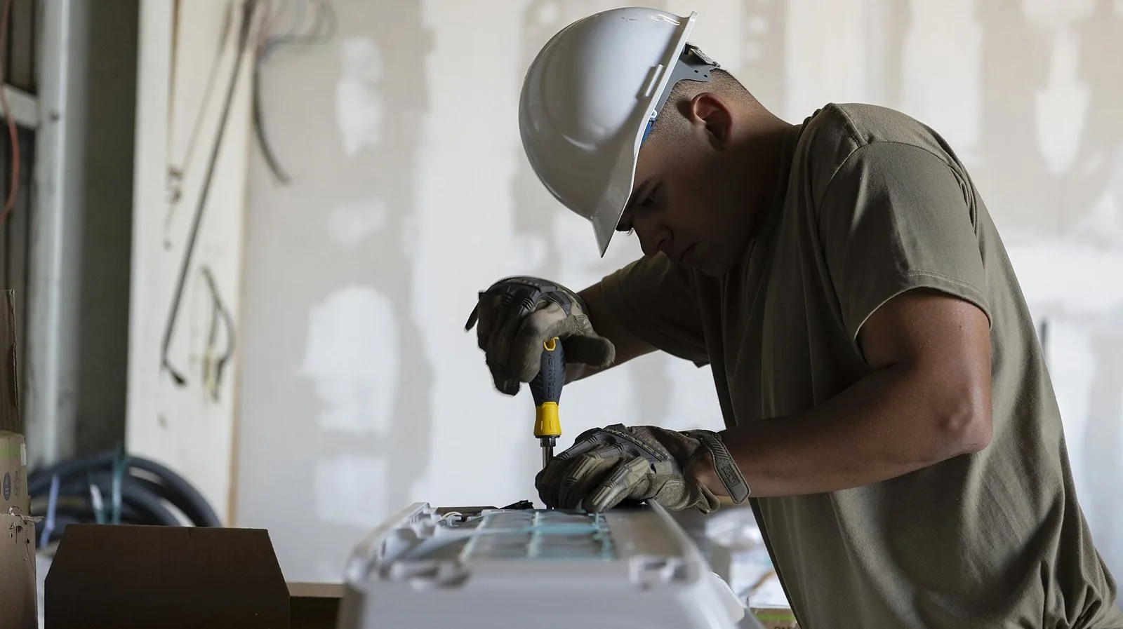 A technician fastening the casing of a split air conditioner indoor unit